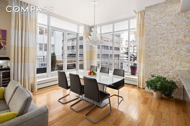 59 John St Unit Ph1, New York City, NY 10038 - dining space with baseboard heating, a chandelier, and light wood-style floors