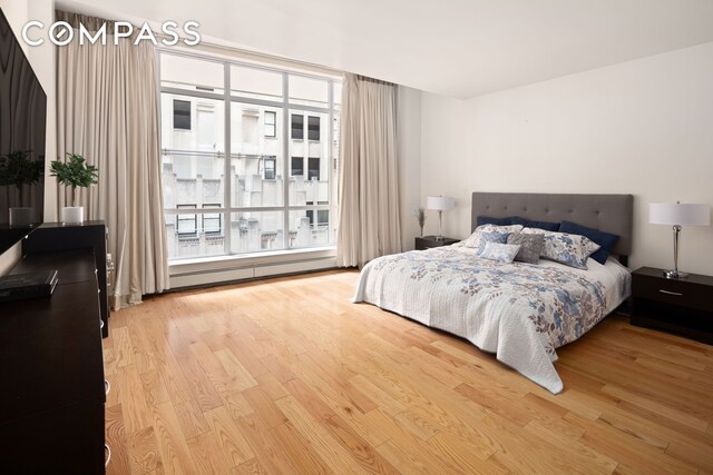 59 John St Unit Ph1, New York City, NY 10038 - bedroom with a baseboard radiator and wood finished floors