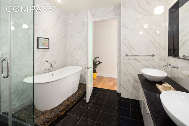 59 John St Unit Ph1, New York City, NY 10038 - full bath featuring tile walls, a freestanding tub, double vanity, a stall shower, and tile patterned floors