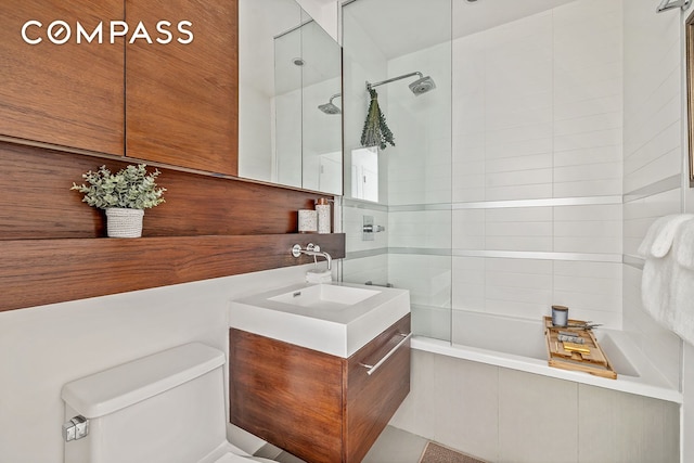 full bathroom with toilet, vanity, and tiled shower / bath combo