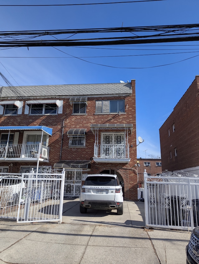 townhome / multi-family property featuring fence and brick siding