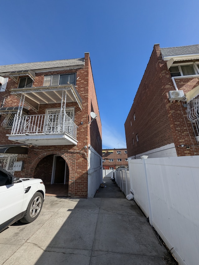 view of property exterior featuring brick siding and fence