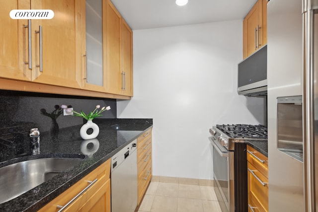 100 United Nations Plz Unit 35E, New York City, NY 10017 - kitchen featuring stainless steel appliances, a sink, light tile patterned floors, dark stone countertops, and glass insert cabinets