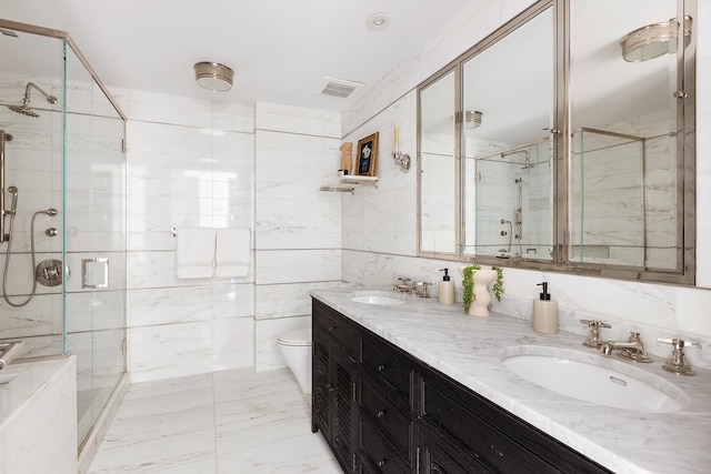 151 E 85th St Unit 19-H, New York City, NY 10028 - bathroom with tile walls, double vanity, a shower stall, and marble finish floors
