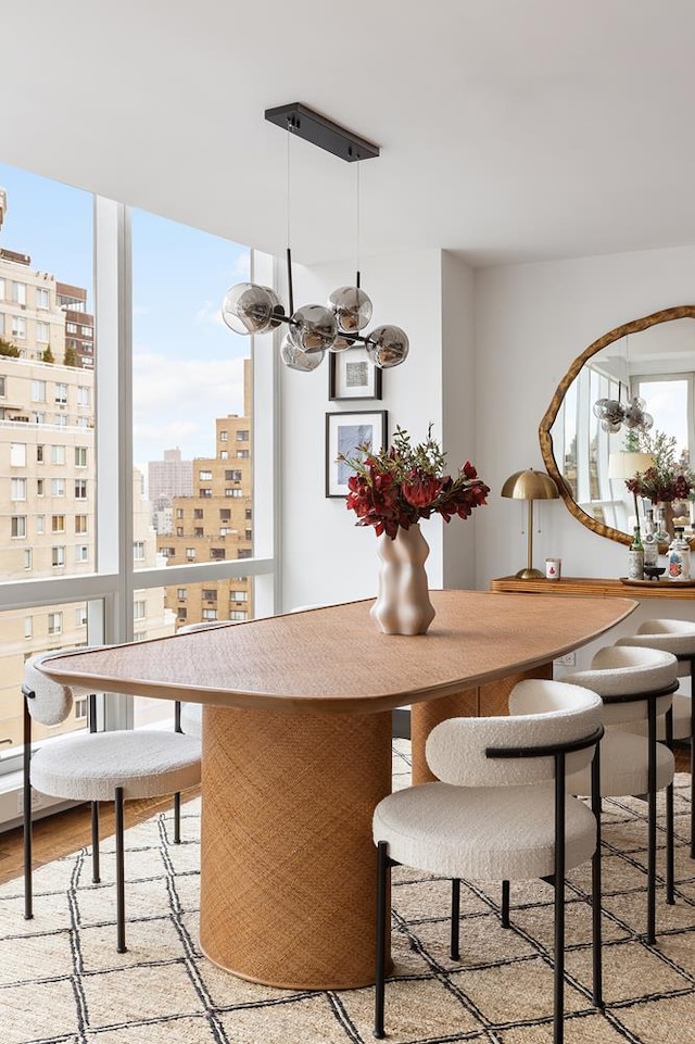 dining room with a chandelier, a view of city, and light wood-style flooring