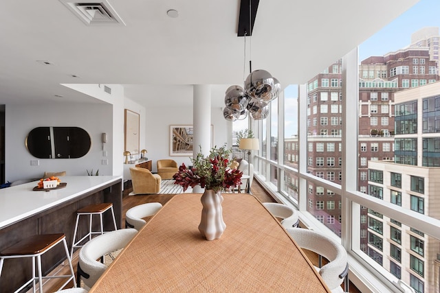 dining room with wood finished floors, a city view, and expansive windows