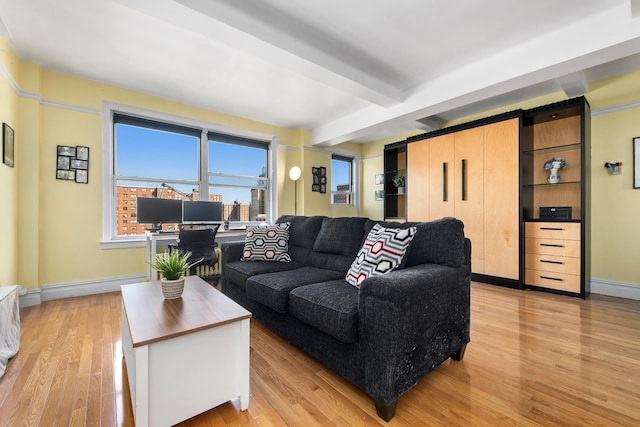 living area featuring light wood-type flooring, beam ceiling, and baseboards