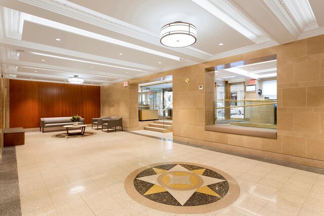 building lobby featuring ornamental molding and wood walls