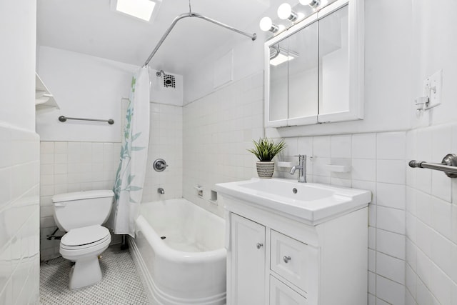full bathroom featuring tile walls, toilet, tile patterned flooring, vanity, and shower / tub combo with curtain