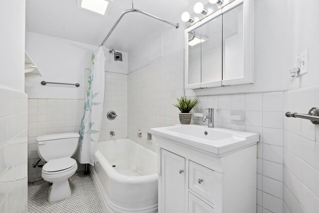 235 W 102nd St Unit 12F, New York City, NY 10025 - full bathroom featuring tile walls, toilet, tile patterned flooring, vanity, and shower / tub combo with curtain