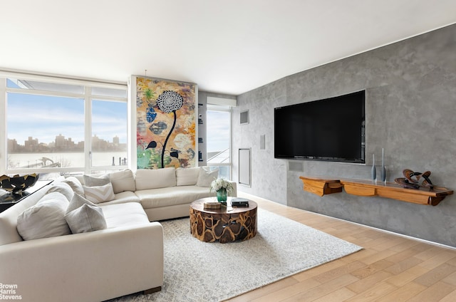 living room featuring wood finished floors, a city view, and expansive windows