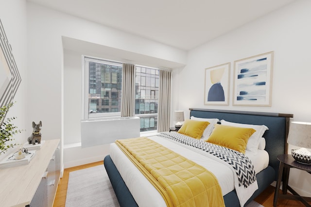bedroom with light wood-style flooring and baseboards