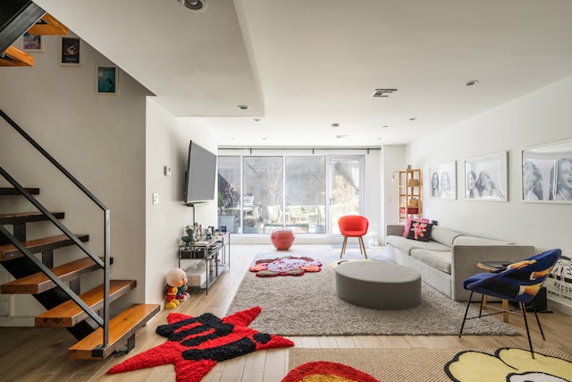 307 Cooper St Unit 1B, New York City, NY 11237 - living area with wood finished floors, stairs, recessed lighting, and floor to ceiling windows