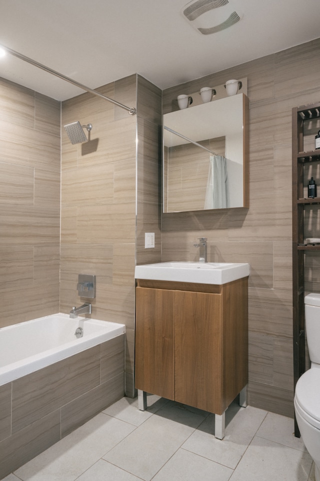 307 Cooper St Unit 1B, New York City, NY 11237 - full bathroom with tile patterned floors, toilet, tile walls, tiled shower / bath combo, and vanity