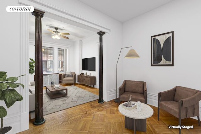 sitting room featuring ceiling fan and ornate columns