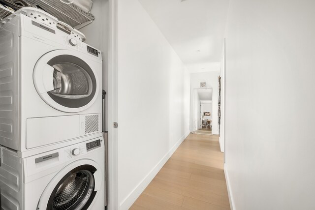 269 4th Ave Unit 403, New York City, NY 11215 - washroom featuring stacked washer and clothes dryer, light wood-type flooring, and baseboards