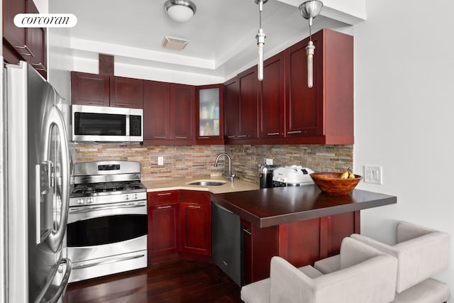 607 Manhattan Ave Unit 1, New York City, NY 11222 - kitchen with appliances with stainless steel finishes, reddish brown cabinets, backsplash, and dark wood-style floors
