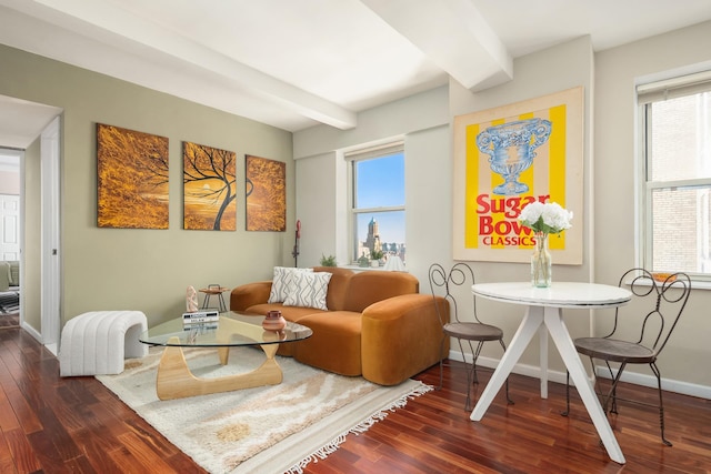 sitting room with baseboards, plenty of natural light, beamed ceiling, and wood finished floors