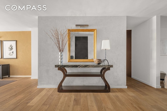 corridor featuring wood finished floors and baseboards