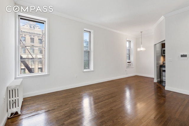 unfurnished living room with crown molding, baseboards, radiator, and dark wood finished floors