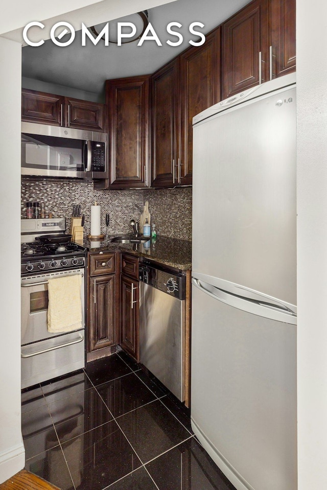 kitchen featuring a sink, backsplash, dark brown cabinetry, and stainless steel appliances