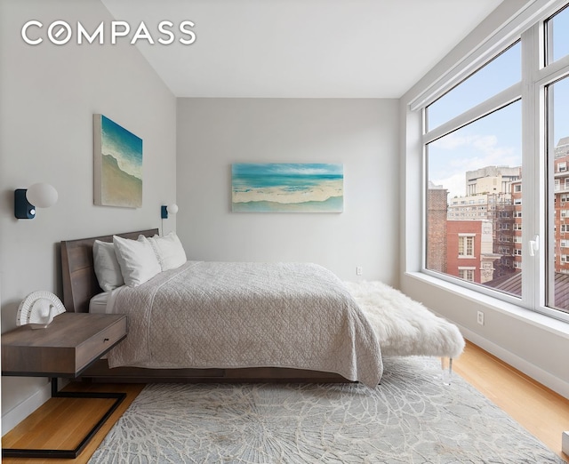 bedroom with wood finished floors and baseboards