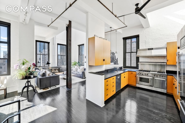 kitchen featuring double oven range, dishwashing machine, a sink, under cabinet range hood, and dark countertops