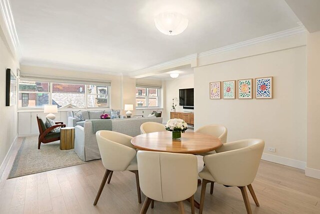40 E 78th St Unit 5F, New York City, NY 10075 - dining area featuring crown molding, light wood-style floors, and baseboards