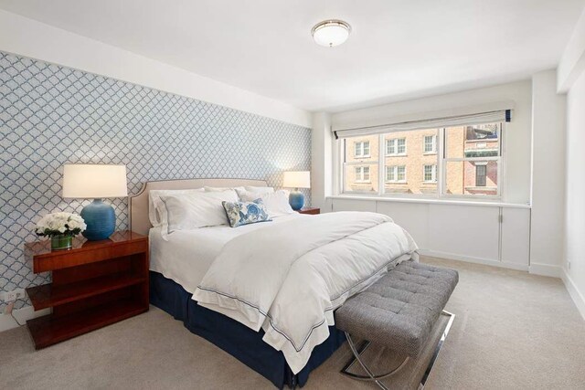 40 E 78th St Unit 5F, New York City, NY 10075 - bedroom featuring light carpet, baseboards, wallpapered walls, and an accent wall