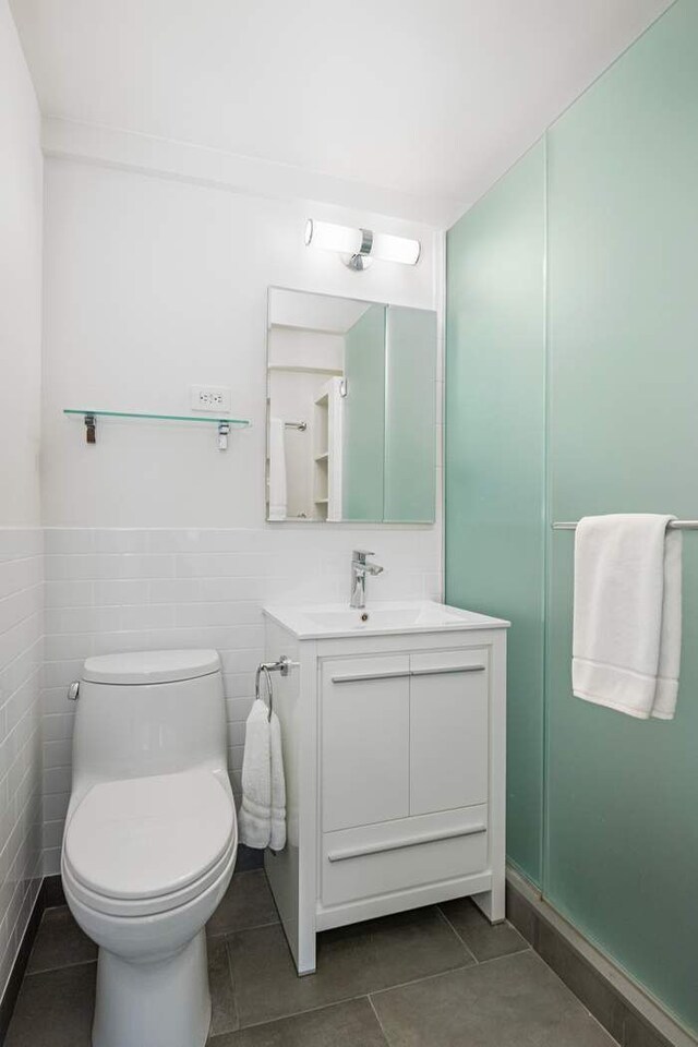40 E 78th St Unit 5F, New York City, NY 10075 - bathroom featuring tile patterned flooring, vanity, tile walls, toilet, and wainscoting
