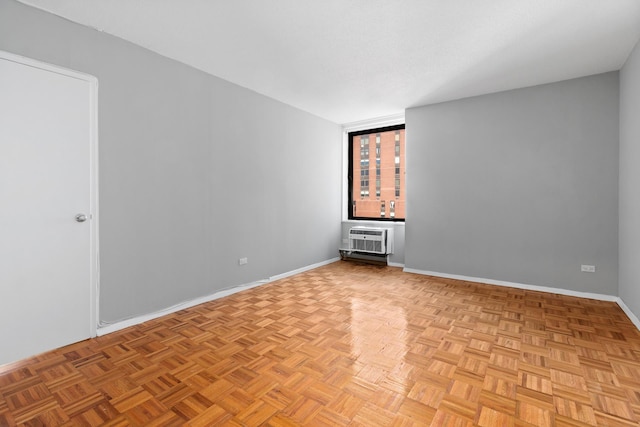 unfurnished room with a bar, an AC wall unit, and baseboards