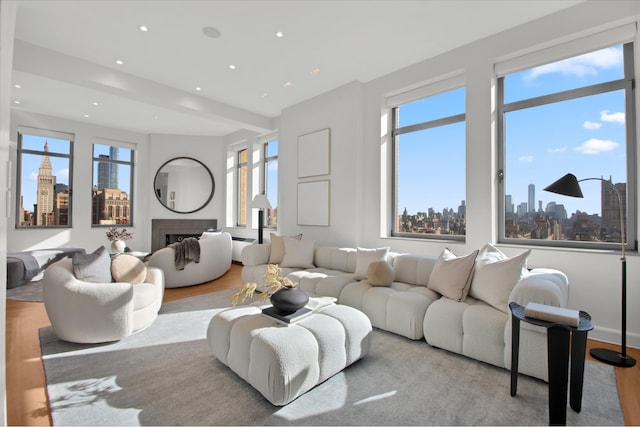 252 7th Ave Pho, Pho, New York City, NY 10001 - living area featuring wood finished floors, a skyline view, a fireplace, and recessed lighting
