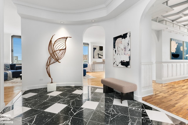 hall featuring arched walkways, plenty of natural light, crown molding, marble tiled flooring, and recessed lighting