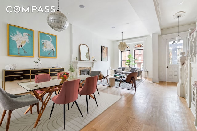 dining space with a brick fireplace and light wood-type flooring