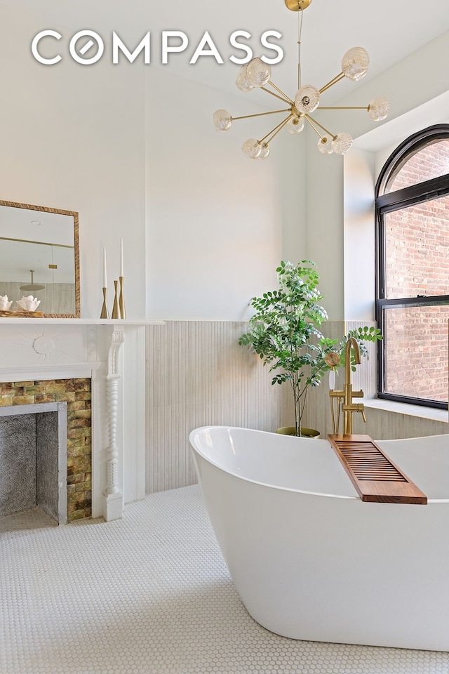 bathroom featuring a freestanding bath, wainscoting, and a fireplace