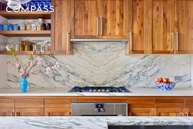 90 Furman St Unit N510, New York City, NY 11201 - kitchen featuring decorative backsplash, stainless steel gas stovetop, open shelves, under cabinet range hood, and light stone countertops