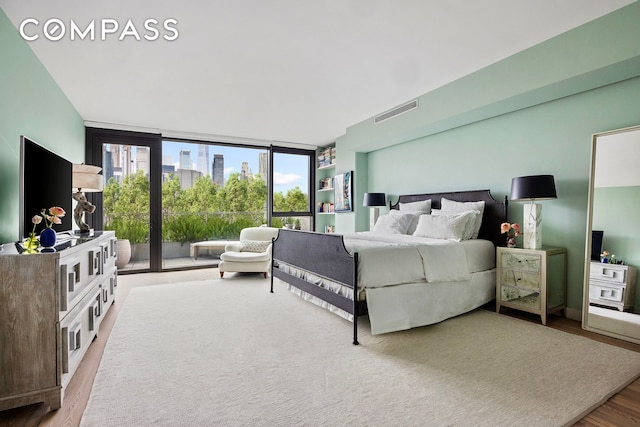 90 Furman St Unit N510, New York City, NY 11201 - bedroom featuring a wall of windows, wood finished floors, and access to outside