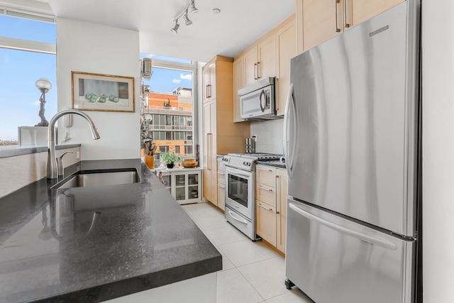 415 Main St Unit Ph-1G, New York City, NY 10044 - kitchen with appliances with stainless steel finishes, light tile patterned flooring, light brown cabinets, rail lighting, and backsplash