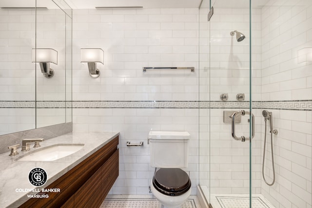 full bath featuring vanity, a stall shower, toilet, and tile walls