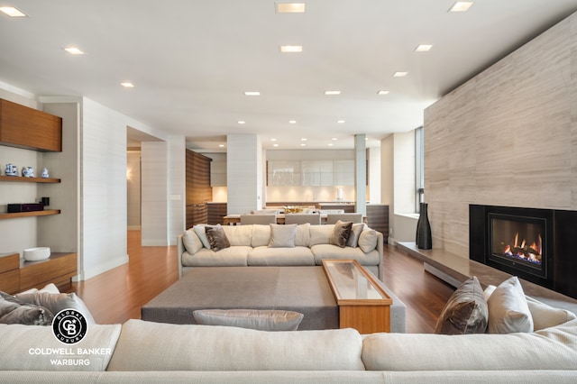 living room with baseboards, a fireplace, recessed lighting, and wood finished floors