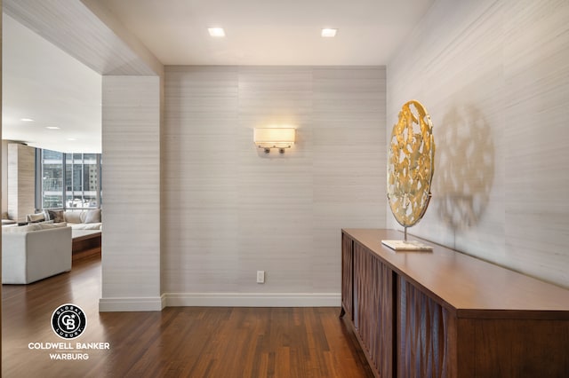 hall featuring baseboards and dark wood-type flooring