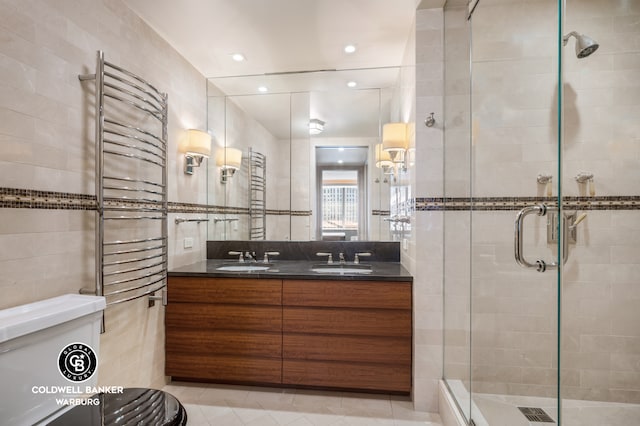 full bathroom featuring a sink, a stall shower, and tile walls
