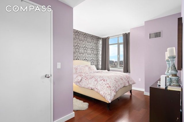 bedroom with wood finished floors and baseboards
