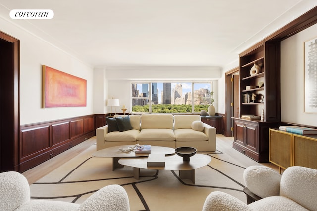 living area featuring a wainscoted wall, light wood-type flooring, and a view of city