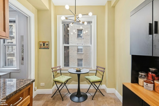 dining space featuring breakfast area, a chandelier, and baseboards