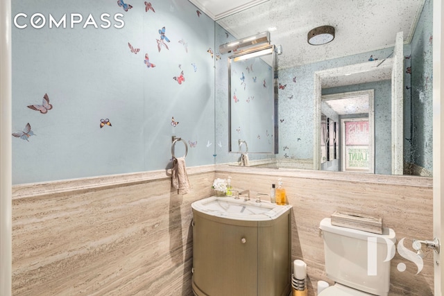 135 E 79th St Unit 8E, New York City, NY 10075 - bathroom with vanity, toilet, wainscoting, and tile walls