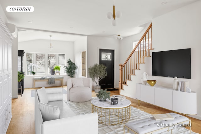living room featuring visible vents, a wall mounted air conditioner, wood finished floors, and stairway