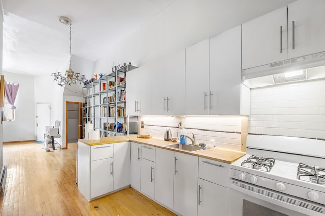 867 Riverside Dr, New York City, NY 10032 - kitchen with white gas range, a sink, under cabinet range hood, decorative backsplash, and a chandelier