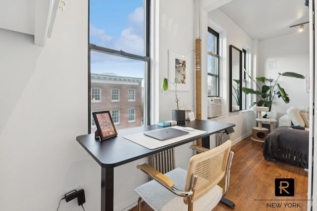 office area featuring healthy amount of natural light, hardwood / wood-style flooring, baseboards, and cooling unit
