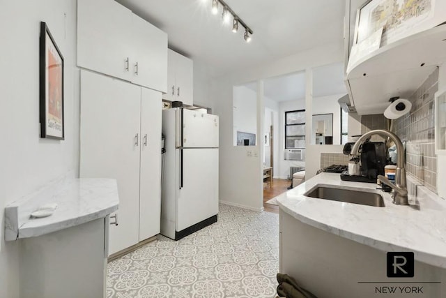 64 Macdougal St Unit 12, New York City, NY 10012 - kitchen with freestanding refrigerator, a sink, tasteful backsplash, white cabinetry, and light stone counters